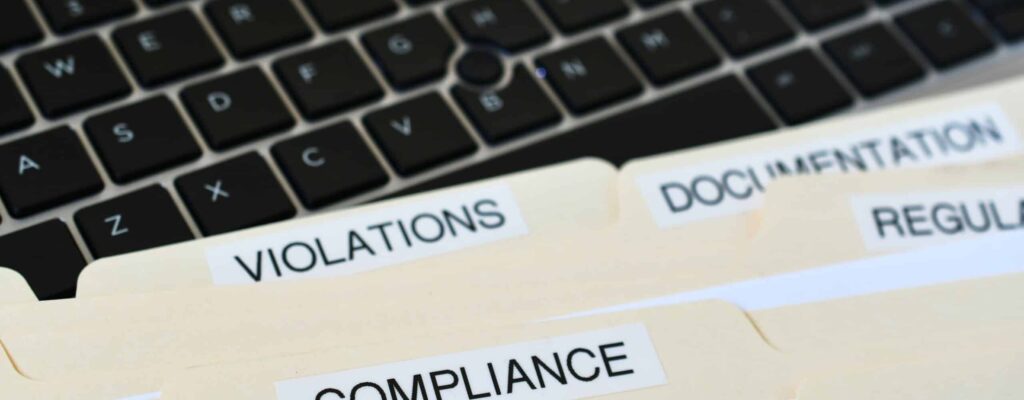 Files folders titled violations, compliance, regulation, and documentation