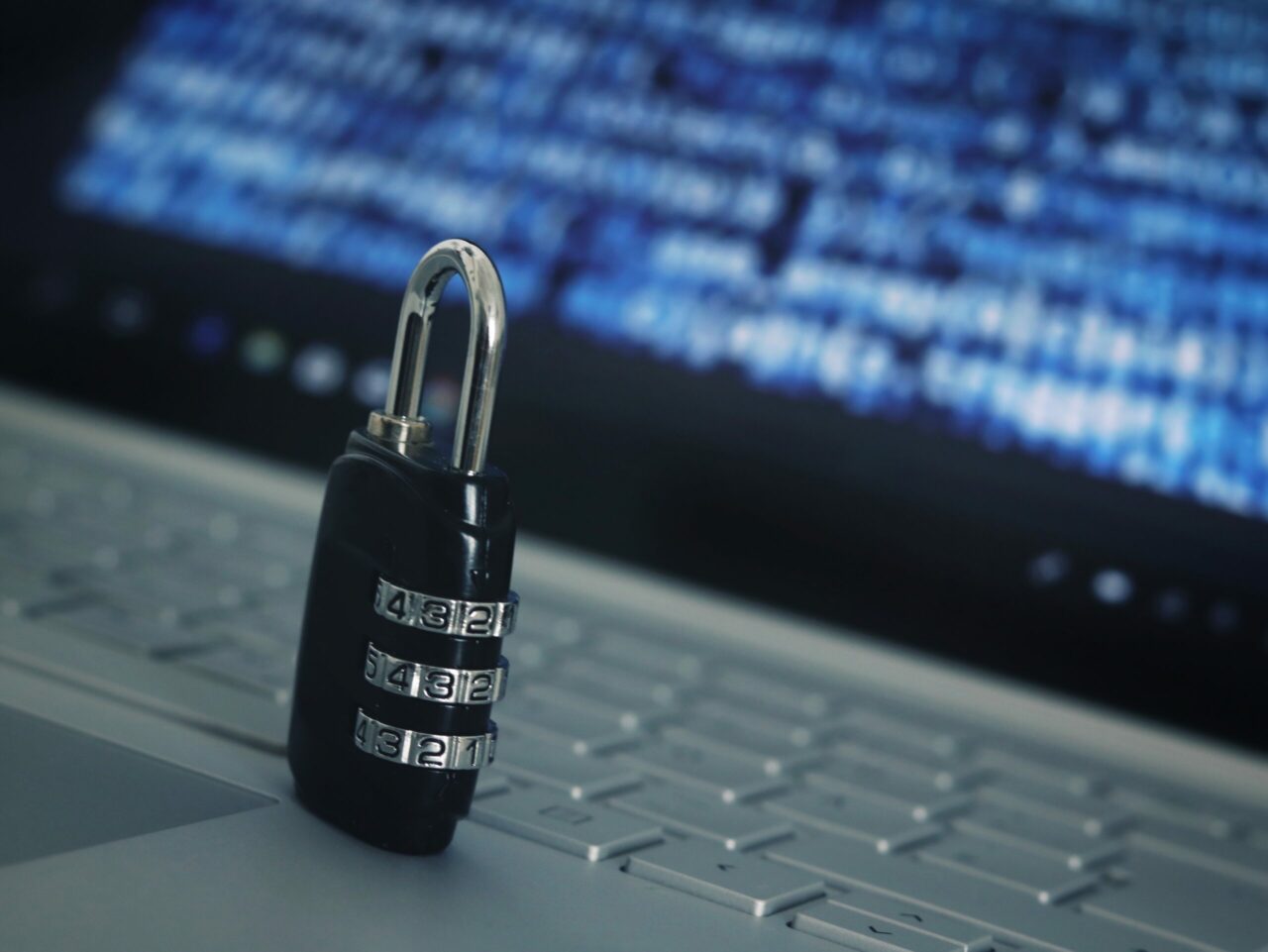 combination lock sitting on a keyboard representing cybersecurity measures