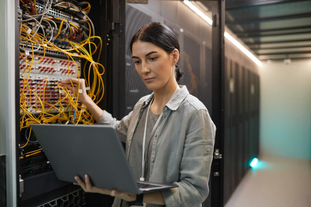 woman connecting cables in data center