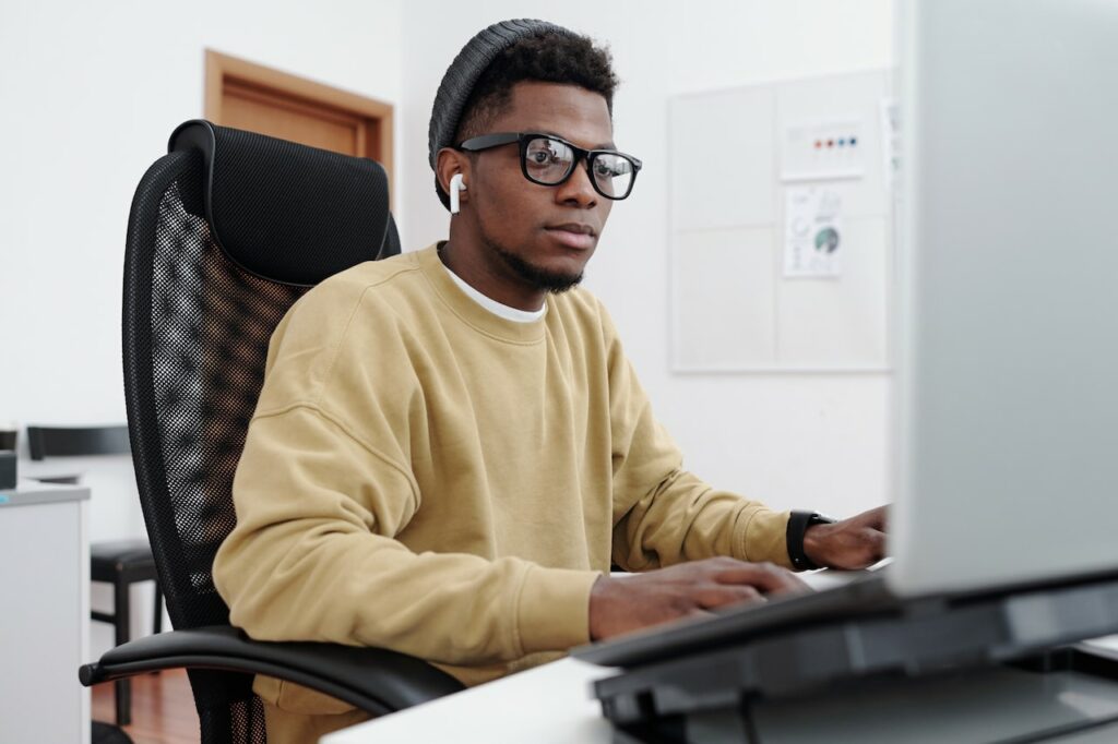 man working on his computer at his desk learning about ways to improve cybersecurity infrastructure